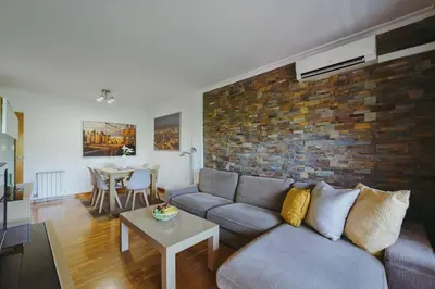 a living room with a couch and a brick wall at 3 bedroom Huge apartament near the beach in Sant Adria de Besos
