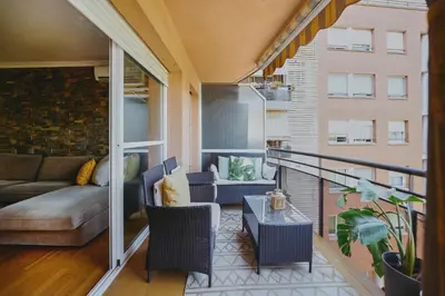 a balcony with a couch and a table at 3 bedroom Huge apartament near the beach in Sant Adria de Besos