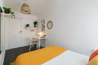 a white bedroom with a bed and a desk at Toledo House Self Checkin in Hospitalet de Llobregat