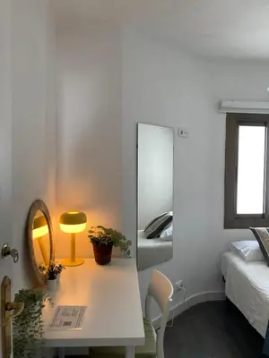 a bedroom with a mirror and a table with a lamp at Toledo House Self Checkin in Hospitalet de Llobregat