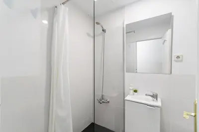 a white bathroom with a shower and a sink at Toledo House Self Checkin in Hospitalet de Llobregat