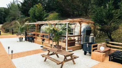 a gazebo with a table and a wooden bench at Caravana Airstream Vintage del 67 en Orrius, Barcelona in Orrius