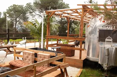 an outdoor patio with a grill and a trailer at Caravana Airstream Vintage del 67 en Orrius, Barcelona in Orrius