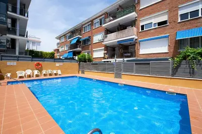 a swimming pool in front of a building at Namasté by Seaside Homes in Castelldefels