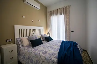 a bedroom with a bed with pillows and a window at Casa grande con piscina en el centro de Calella, Tramuntana in Calella