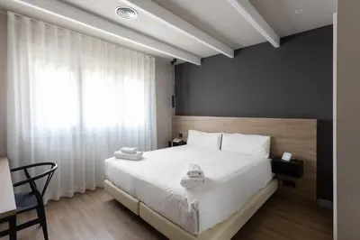a bedroom with a large white bed and a window at Mas de la Sala in Sallent del Llobregat