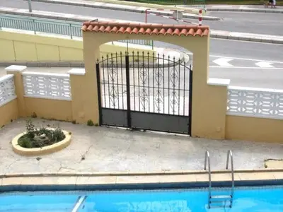 a gate in a building next to a swimming pool at Apartamento Pineda de Mar en Primera Línea in Pineda de Mar