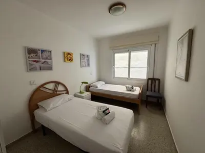 a bedroom with two beds and a window at Apartamento Pineda de Mar en Primera Línea in Pineda de Mar