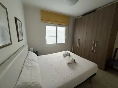 a bedroom with a white bed with towels on it at Apartamento Pineda de Mar en Primera Línea in Pineda de Mar