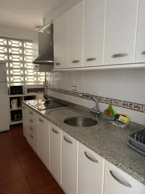 a kitchen with a sink and white cabinets at Apartamento Pineda de Mar con Vistas al Mar in Pineda de Mar