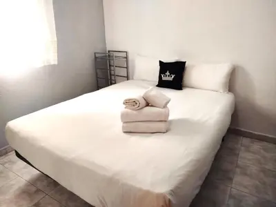 a white bed with a pile of towels on it at La habitación de Santa Eulalia in Hospitalet de Llobregat