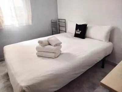 a white bed with towels on top of it at La habitación de Santa Eulalia in Hospitalet de Llobregat