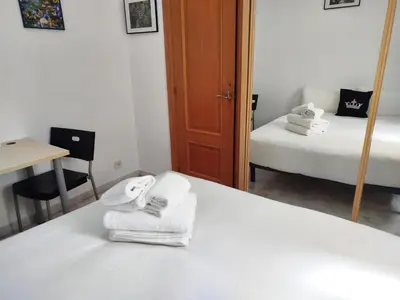 a bedroom with a bed with towels and a mirror at La habitación de Santa Eulalia in Hospitalet de Llobregat