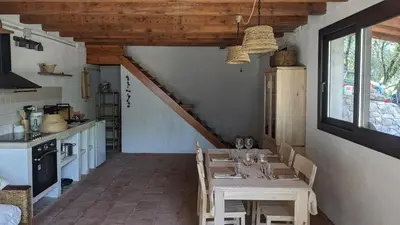 a dining room with a table and a kitchen at La Coma in gualba de Dalt