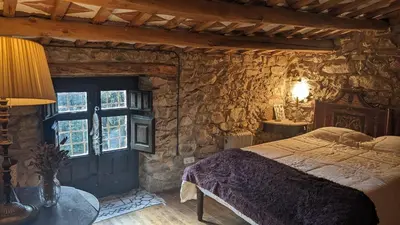 a bedroom with a bed and a stone wall at La Coma in gualba de Dalt