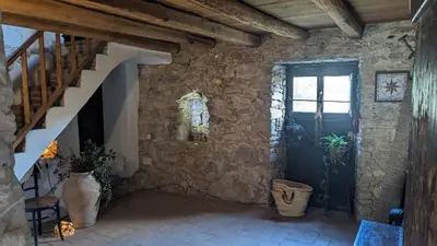 a room with a staircase and a stone wall at La Coma in gualba de Dalt