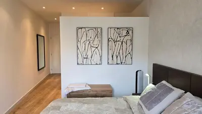a bedroom with a bed and two paintings on the wall at Opening Doors Summer Chic in Barcelona