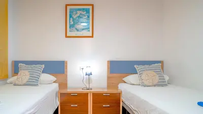 two twin beds in a room with a picture on the wall at Vivalidays Margarita - Pineda de Mar in Pineda de Mar