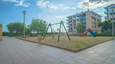 a playground with two swings in a park at Vivalidays Margarita - Pineda de Mar in Pineda de Mar