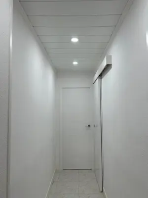 a hallway with white walls and a ceiling at Apartamento con Terraza,Piscina,Playa y Aire acondicionado in Pineda de Mar