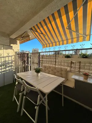 a table and chairs under a tent on a balcony at Apartamento con Terraza,Piscina,Playa y Aire acondicionado in Pineda de Mar