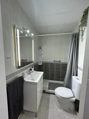 a white bathroom with a sink and a toilet at Apartamento con Terraza,Piscina,Playa y Aire acondicionado in Pineda de Mar