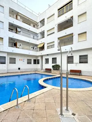 a swimming pool in front of a building at Apartamento con Terraza,Piscina,Playa y Aire acondicionado in Pineda de Mar