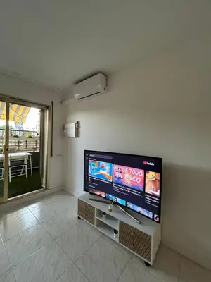 a living room with a flat screen tv on a wall at Apartamento con Terraza,Piscina,Playa y Aire acondicionado in Pineda de Mar