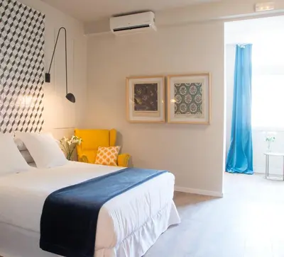a bedroom with a bed and a yellow chair at The Conica Deluxe Bed&Breakfast in Barcelona