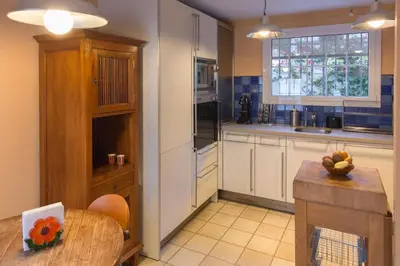a kitchen with white cabinets and a table and a window at Stunning sea views over marina with swimming pool in Sitges