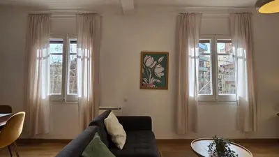 a living room with a couch and two windows at Opening Doors Sant Pau II Centric AACC in Barcelona