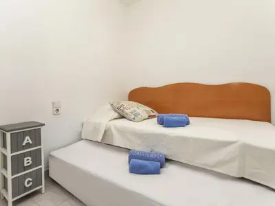 a bedroom with a bed with two blue pillows on it at Apartment Bahia by Interhome in Cunit