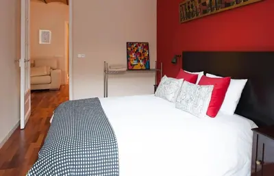 a bedroom with a large bed with red walls at Barcelona - Provença in Barcelona