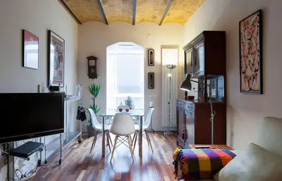 a living room with a table and chairs and a television at Barcelona - Provença in Barcelona
