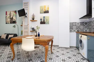 a living room with a wooden table and white chairs at EXT Studio todo equipado, 15' de BCN centro 8' playa in Sant Adria de Besos