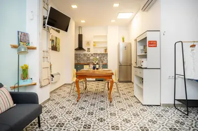a small kitchen with a table and a refrigerator at EXT Studio todo equipado, 15' de BCN centro 8' playa in Sant Adria de Besos