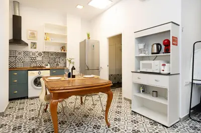 a kitchen with a table and a refrigerator at EXT Studio todo equipado, 15' de BCN centro 8' playa in Sant Adria de Besos