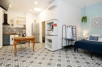 a kitchen with a refrigerator and a table in a room at EXT Studio todo equipado, 15' de BCN centro 8' playa in Sant Adria de Besos