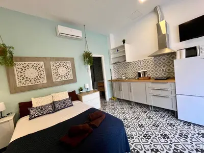 a bedroom with a large bed and a kitchen at INT Studio totalmente equipado, 15' de BCN centro 8' playa in Sant Adria de Besos