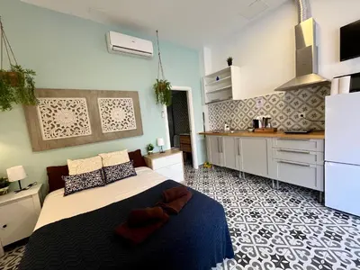 a bedroom with a large bed and a kitchen at INT Studio totalmente equipado, 15' de BCN centro 8' playa in Sant Adria de Besos