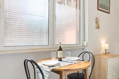 a dining room table with a bottle of wine on it at INT Studio totalmente equipado, 15' de BCN centro 8' playa in Sant Adria de Besos