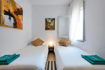 two twin beds in a room with a window at 2º Apartamento 3 hab 15' Barcelona centro y 8' Playa caminando in Sant Adria de Besos