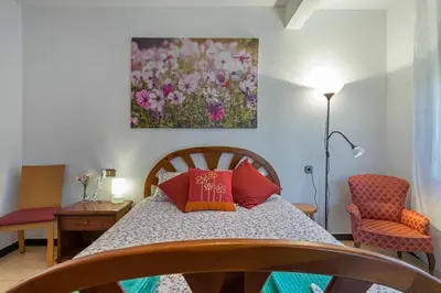 a bedroom with a bed with red pillows and a painting at 2º Apartamento 3 hab 15' Barcelona centro y 8' Playa caminando in Sant Adria de Besos