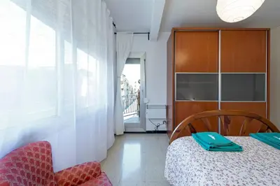 a bedroom with a bed and a cabinet and a chair at 2º Apartamento 3 hab 15' Barcelona centro y 8' Playa caminando in Sant Adria de Besos
