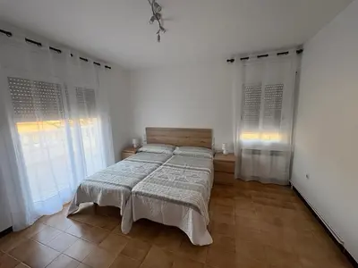 a bed in a room with white walls and windows at casa en Palau in Palau-Solità i Plegamans