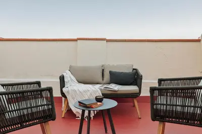 a couch on a patio with two chairs and a table at Balat - 2 bedrooms and terrace in Eixample Dreta in Barcelona