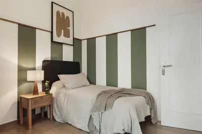 a bedroom with green and white walls and a bed at Reis - 3 bedrooms and balcony in Vila de Gràcia in Barcelona