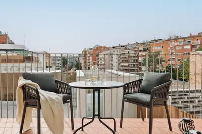 a table and chairs on a balcony with a view of a city at Serralada - 4 bedrooms and terrace in Sant Gervasi in Barcelona
