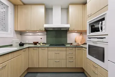 a kitchen with wooden cabinets and a stove top oven at Serralada - 4 bedrooms and terrace in Sant Gervasi in Barcelona