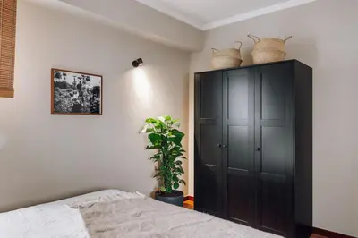 a bedroom with a black cabinet and a plant at Holo - 2 bedrooms in Eixample Dreta in Barcelona